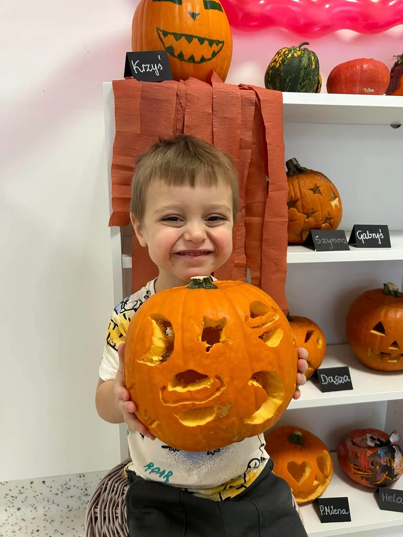 Chłopiec z przedszkola SunnyKids w Krakowie prezentujący wydrążoną dynię podczas zajęć tematycznych z okazji Halloween